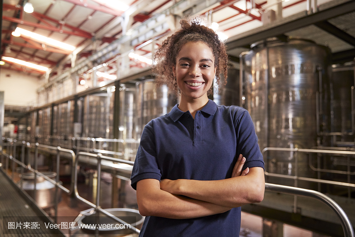 年輕的混血婦女在葡萄酒工廠工作的肖像